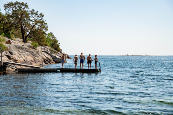 Barn som står på en brygga ute i havet.