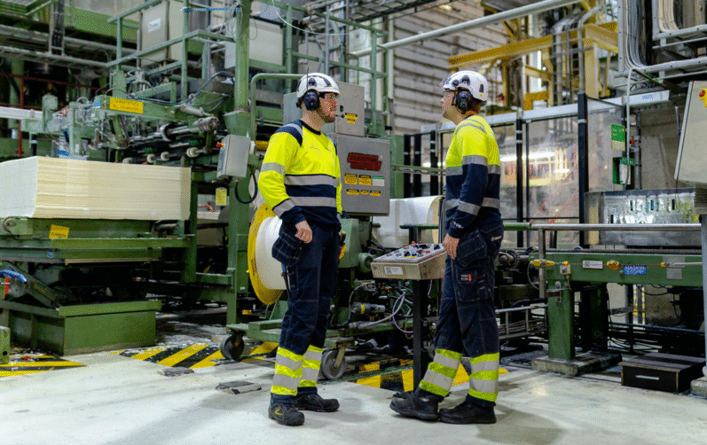 Två personer i industrimiljö.