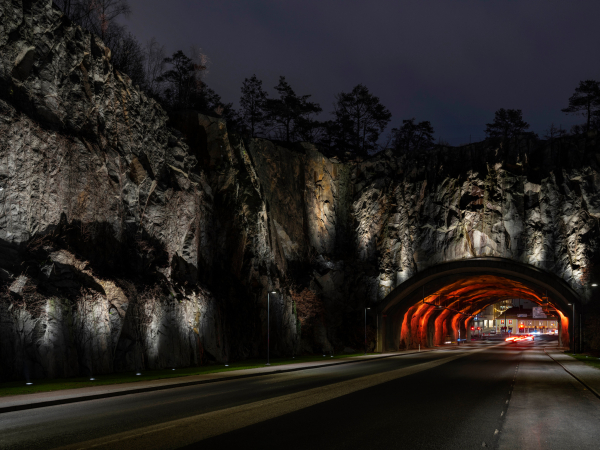 Hinseberget med upplysta bergväggar och belysning inuti tunneln.