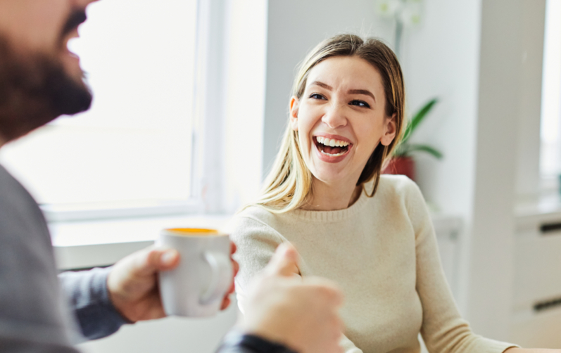 Två glada personer vid ett mötesbord.