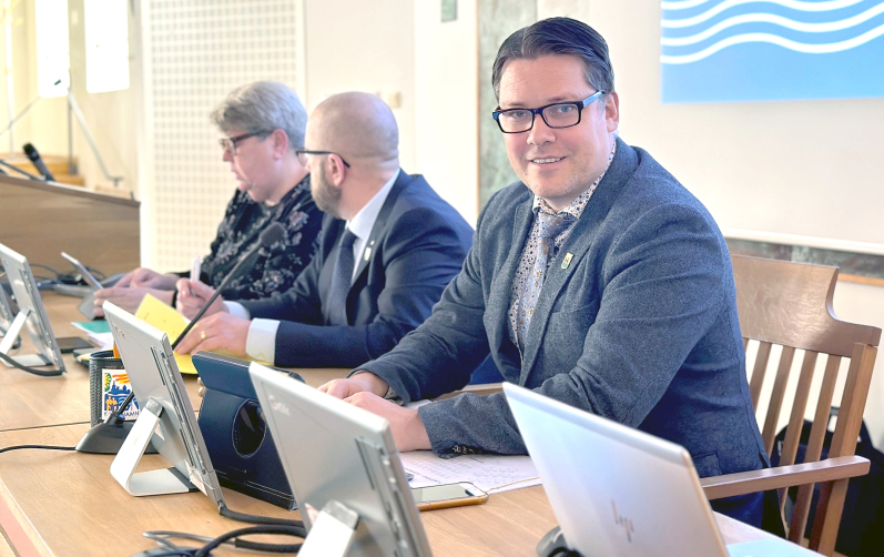 Tre politiker framför sina datorskärmar i Rådhussalen i Karlshamn.